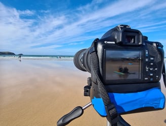 A Canon DSLR camera on a tripod at the beach for video analysis session