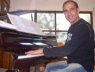 a man sitting at a piano playing a piano