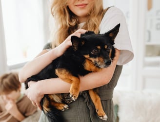 A blonde woman holding a dog