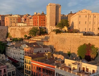 a cityscape of buildings and a castleof Cagliar in Piazza Yenne