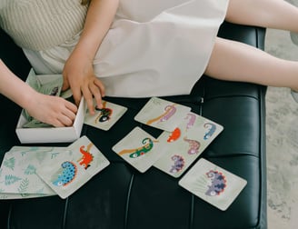 a girl sitting on a bench with a card game
