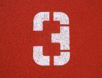 a number three on a red surface of a tennis court
