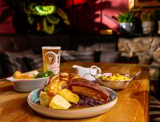 Roast dinner on a table in the snug area with a pint of beer