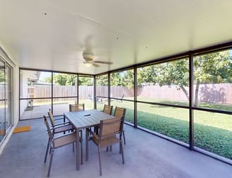 a patio with a table and chairs and a ceiling fan