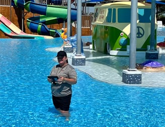 a woman inspector standing in a kiddie splash pool