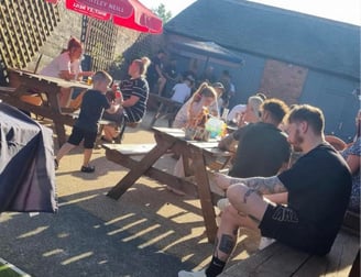 a group of people sitting in a beer garden