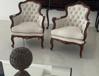 Um par de poltronas de madeira estilo clássica reformadas em linho bege claro