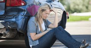 a woman sitting on the ground with her head in her hands