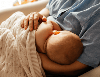 a baby is laying on a couch with a baby