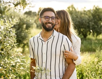 Provence couple session in olive grove — she whispers in his ear, laughing, in fine art style