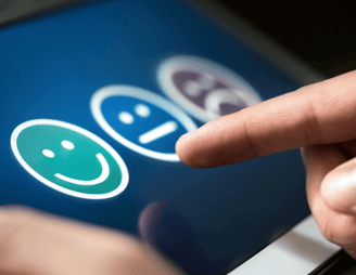 User selecting happy face on touchscreen for customer feedback | Measuring customer engagement