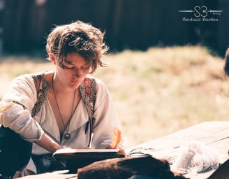 Plan d'une personne en tenue médiévale écrivant dans un livre avec une plume