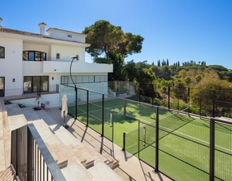 Private paddle tennis court at Villa La Gratitud, surrounded by lush greenery.