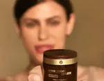 femme tient un pot de creme