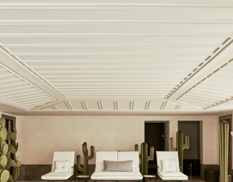 Indoor heated pool at Villa La Gratitud, with lounge beds, potted palms, and garden views beyond.