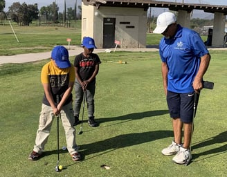 Enhancing Forward Action image of golf instructor teaching young students how to put