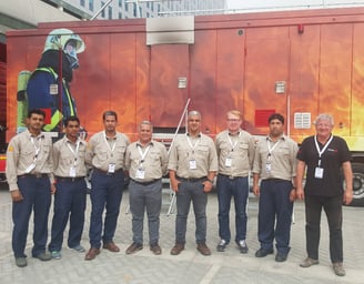 Premiers For Equipment Managers & Staff Standing in Front of MTU (Mobile Training Unit)