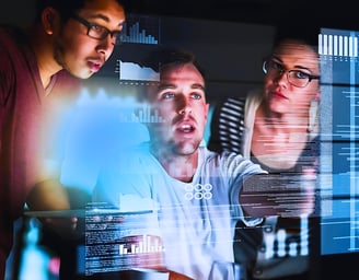 Male leader discussing data with a man and a woman on a computer screen
