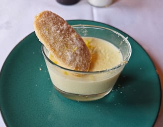 Lemon flavoured dessert with biscuit on green plate