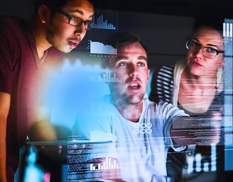 Male leader discussing data with a man and a woman on a computer screen