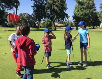 Enhancing Forward Action Inc. image of a group children on a golf course shacking hands
