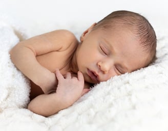 Sessió de fotos newborn a Girona amb una bebè recent nascuda dormint en estudi fotogràfic
