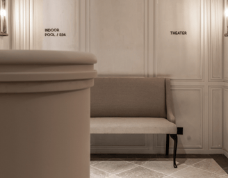 Hallway at Villa La Gratitud, featuring soft lighting, and signs for the pool, spa, and theater.