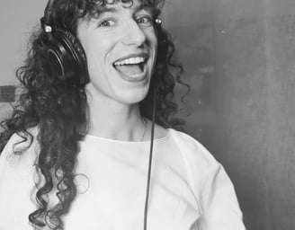 photo en noir et  blanc de aude fy en train de chanter avec casque sur les oreilles