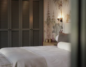 Elegant bedroom with Hamptons-style wardrobes, botanical mural, and soft neutral linens