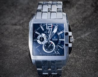 Montre argentée de marque Festina, cadran bleu sur fond pierre noire