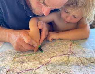 a man and a child are looking at a map