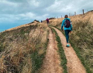 a woman in a blue jacket and a man in a blue jacket are walking up