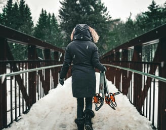 mujer cruzando un puente con nieve
