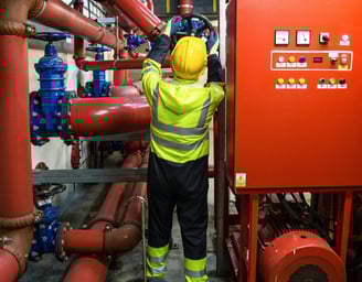 Maintenance worker turning a valvue for a industrial machine