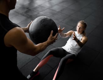 a man and woman doing a medicine exercise