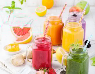 a variety of smoothie drinks in a variety of colors