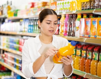 a woman in a white shirt is looking at a yellow pitcher