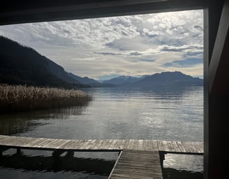 Vue depuis un ponton sur le lac d'Annecy avec au loin les montagnes