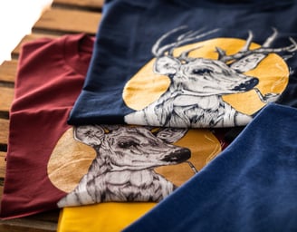 Two graphic t-shirts featuring a stylish deer smoking a pipe, printed design