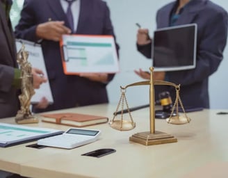 a group of people standing around a table with a laptop and a laptop
