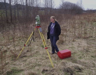 a woman in a field with a tripod and a tripod