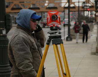 a man in a blue jacket and a camera on a tripod