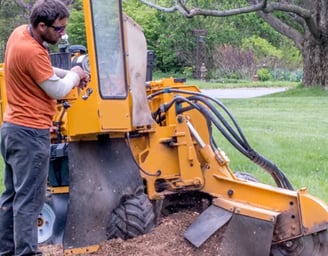 a man is standing in the dirt with a machine