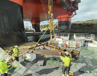 a group of men in yellow vests and safety vests working on a ship