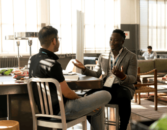 two men sitting at a table with a table with a table cloth