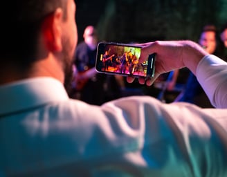 Wedding guest filming the band with a smartphone during live performance