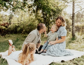 a family of four sitting on a blanket