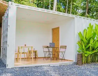 a small container house with a laptop on the ground