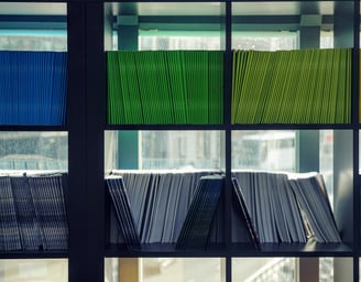 a book shelf with a bunch of folders on it