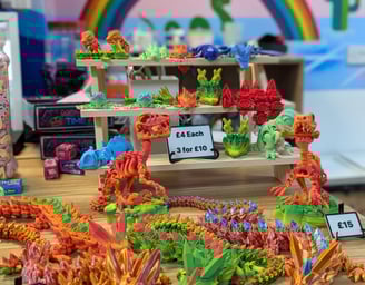 A table with a selection of different coloured 3d prints